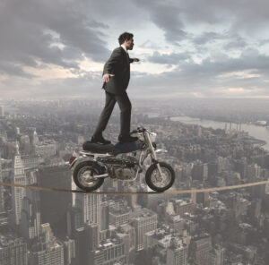 SLAPP attorney riding motorcycle on tightrope