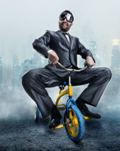 Crazy man in suit riding trike.