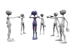 An angry group of white figures standing in a circle, pointing finger at a dotted figure in the middle.